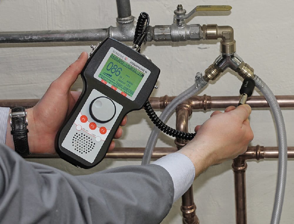 Plumber testing pipes with electronic leak detection equipment in Harrisburg