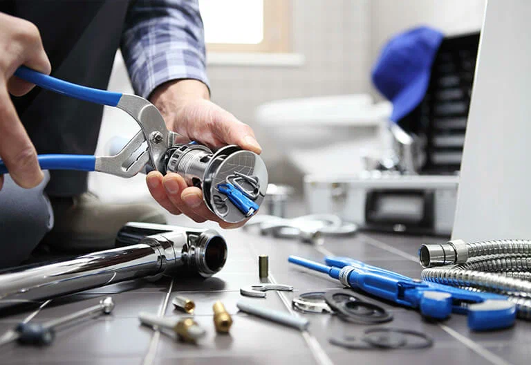 Technician repairing a plumbing fixture with professional tools in Harrisburg