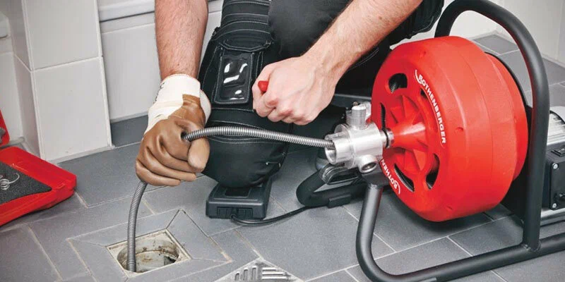 Plumber using a drain-cleaning machine in Harrisburg