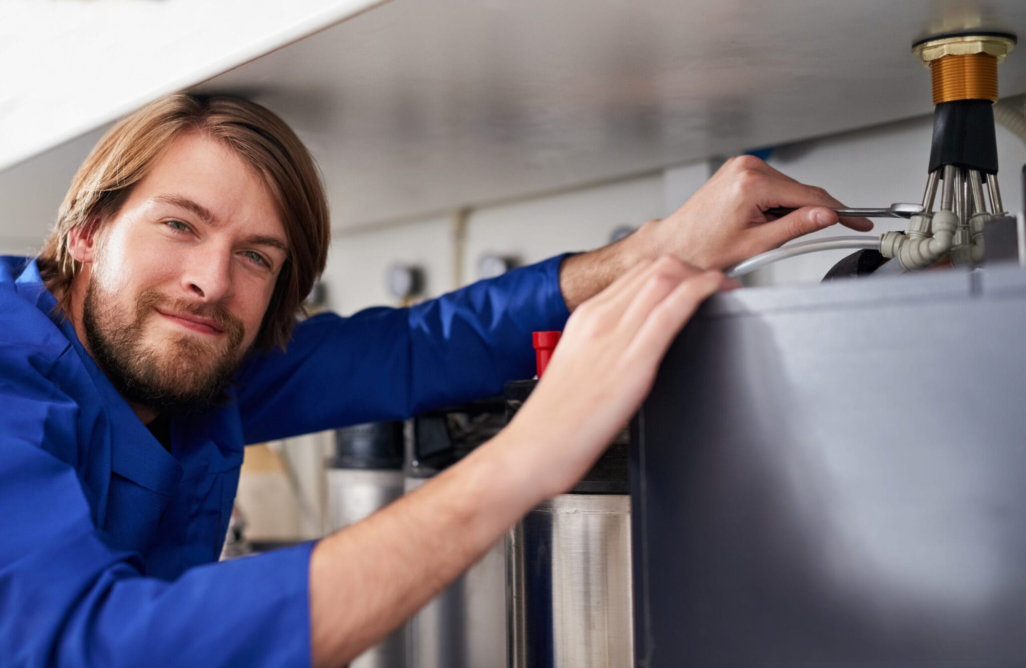 Technician servicing a residential water heater tank in Harrisburg